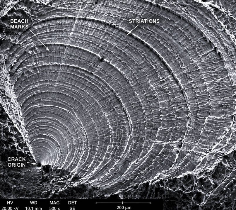SEM image of metal fatigue fracture surface showing beach marks and striations
