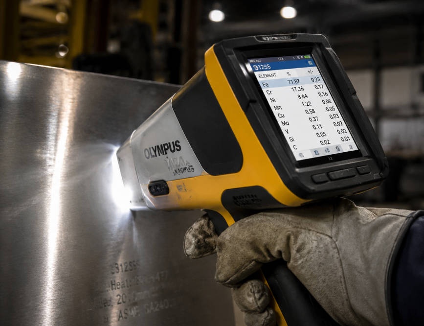 Technician performing XRF analysis on stainless steel sample in the field