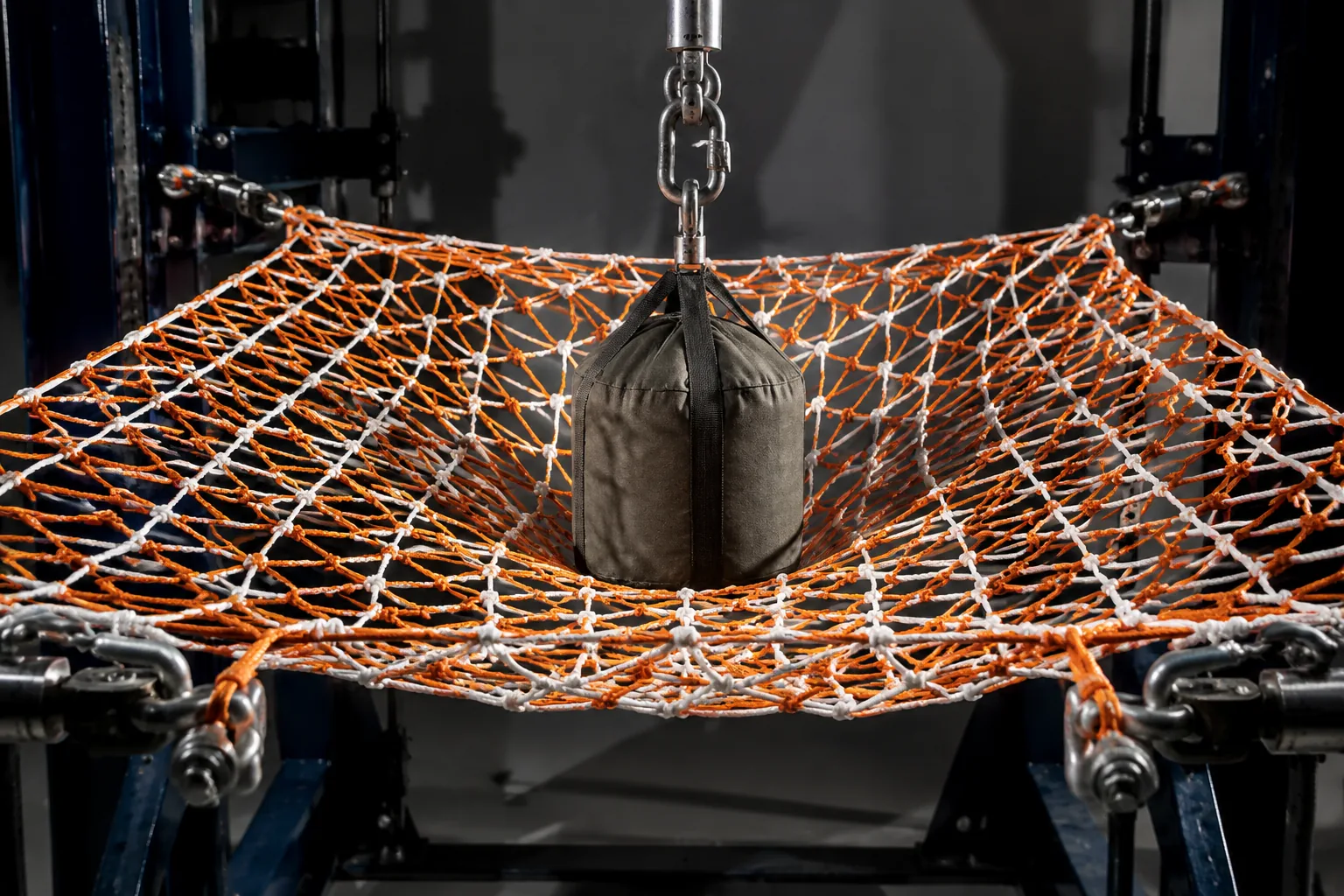 Knotted safety net under impact drop test on a laboratory steel frame with bollard grips and load cell