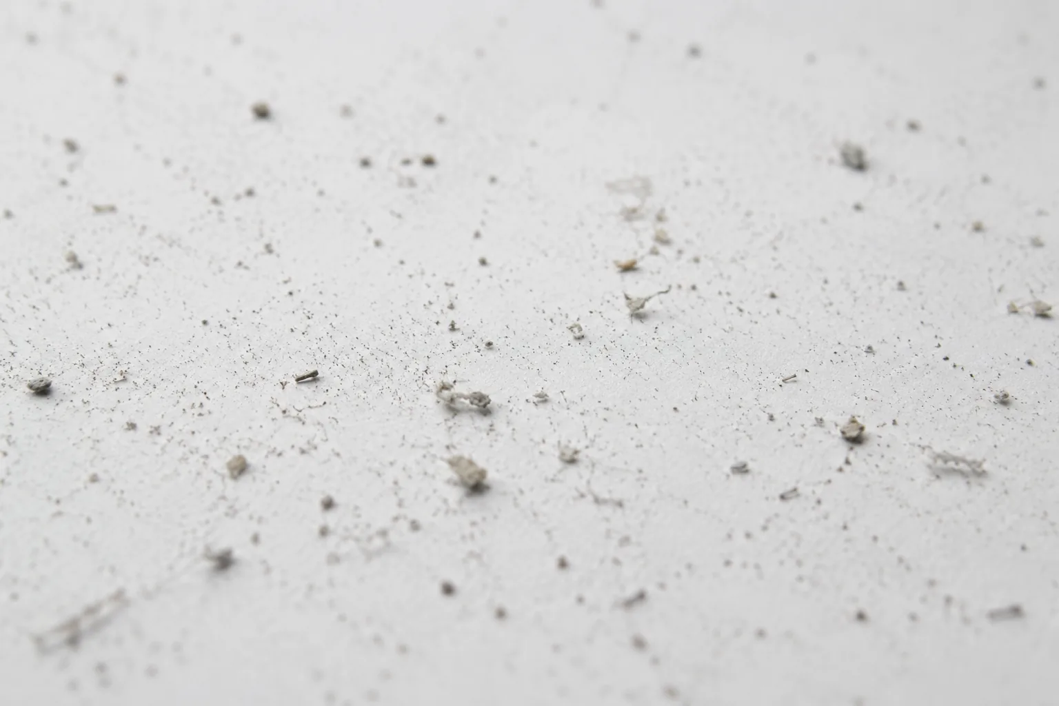 Fine test dust scattered on a smooth white surface — vacuum cleaner pick-up testing to IEC 62885-2 and ASTM F608.